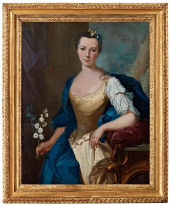 Portrait of a lady standing by a console table, holding white and blue flowers by 
																			Joachim Rupalley