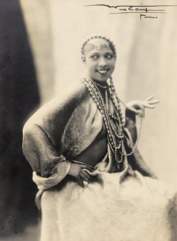 Josephine Baker posing with bead necklaces by 
																	Lucien Walery