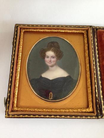 Portrait miniature of a young lady, seated, wearing a dark blue dress with ruffled sleeves and gold belt buckle by 
																			Ferdinand Machera