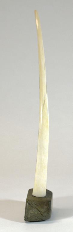 Engraved tusk on a base by 
																			Innuki Oqutaq