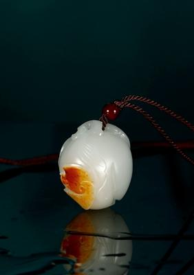 A white jade bat and peach pendant by 
																	 Qu Lijun