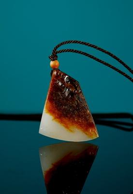 A white jade dragon pendant by 
																	 Qu Lijun