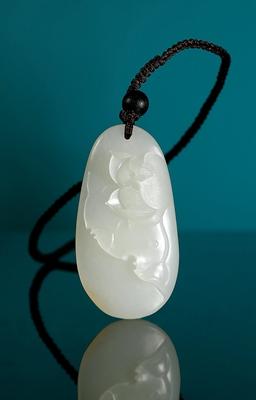 A white jade lotus pendant by 
																	 Yang Xi