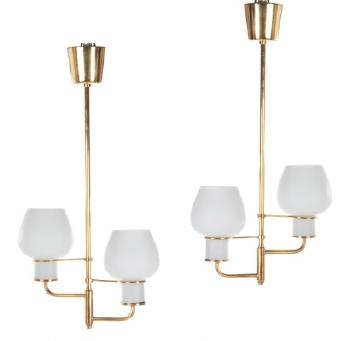 A pair of brass ceiling lamps each with two arms mounted with opal glass shades by 
																	Bent Karlby