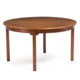 A circular teak dining table with four extension leaves, one with apron, one folding support leg by 
																			 P Lauritsen & Sons