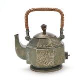 Copper plated kettle with hammered surface. Handle with wicker by 
																			Peter Behrens