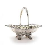 A Russian silver bread basket of oval shape, rim embossed with foliage and rocailles, raised on four feet with sea shell design; swing handle by 
																			Adolf Sper