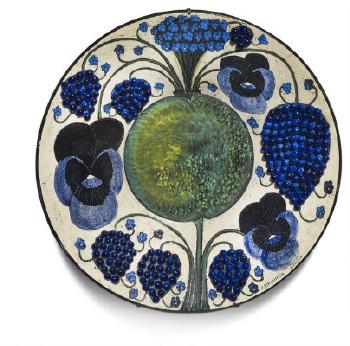 A large circular faience dish with motifs of heartseases fruits and berries by 
																	Birger Kaipiainen
