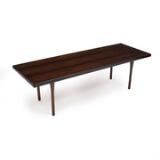 A rectangular rosewood coffee table with round legs. by 
																			Illum Wikkelso