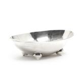 A Danish hammered sterling silver bowl with four feet by 
																			Karl Gustav Hansen
