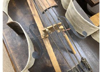 A skeletonised steel scultpure of a cello, with timber fingerboard and wire strings, the interior decorated with musical notes and text by 
																			Nicholas  Juett