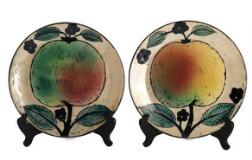 A pair of faience plates decorated with fruit and leaves by 
																			Birger Kaipiainen