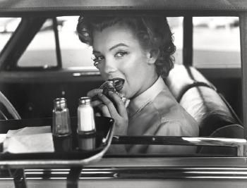 Marilyn Monroe (At a drivein, eating a hamburger) by 
																	Philippe Halsman