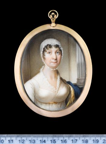 Mrs Mary Robertson, wearing white dress with frill edged gauze fill-in, gold ribbon waistband, gold lined blue cloak over her left shoulder and white lace bonnet held under her chin by 
																	Alexander Gallaway